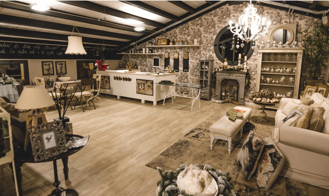 Stile Store: Showroom in stile vintage con divano, camino e lampadario elegante.
